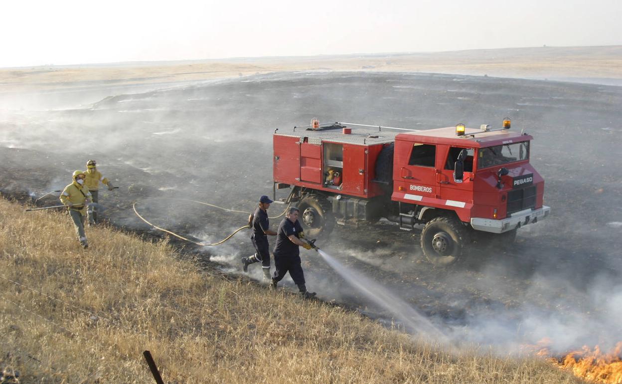 Imagen de archivo de bomberos apagando un incendio en el término municipal de Cáceres. 