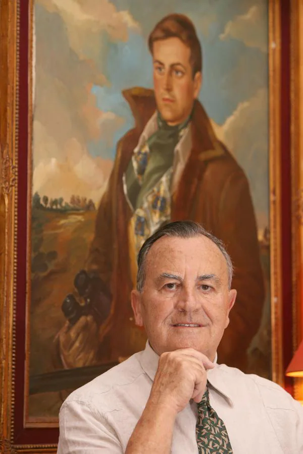Carlos de Villamor en el año 2010 junto al retrato que le pinto su hermano Álvaro ataviado de cazador.