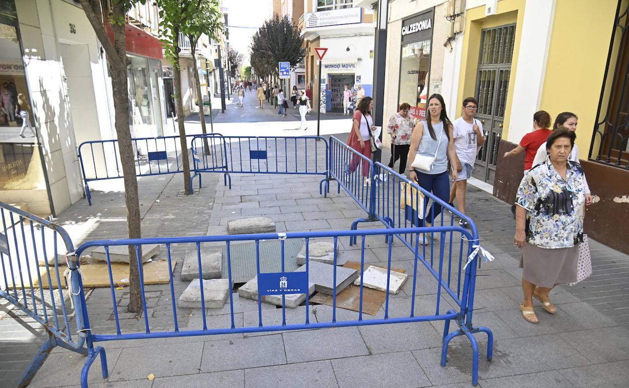 Las vallas que cercan el socavón ocupan más de la mitad de la calle.