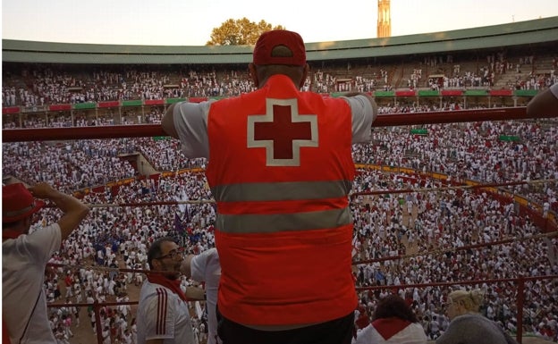 Un miembro de Cruz Roja observa la plaza de toros de Pamplona. 