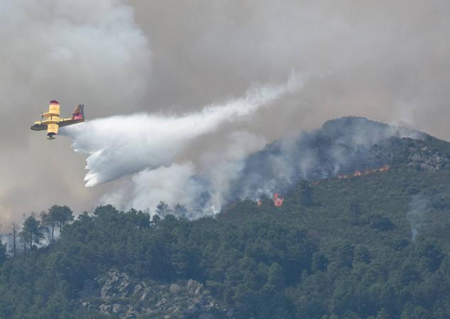 Un hidroavión anfibio contra incendios echa agua sobre la vegetación en la comarca de Las Hurdes