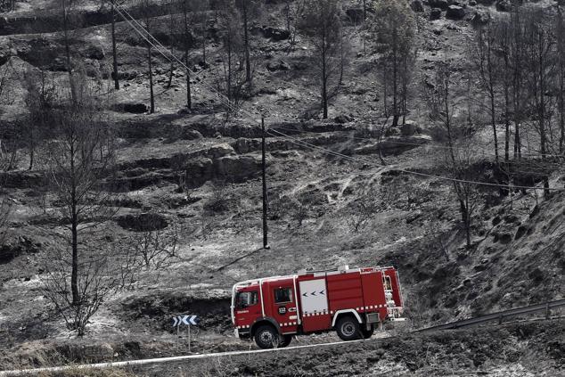 Un camión de bomberos circula por una zona arrasada por las llamas en la población de El Pont de Vilomara