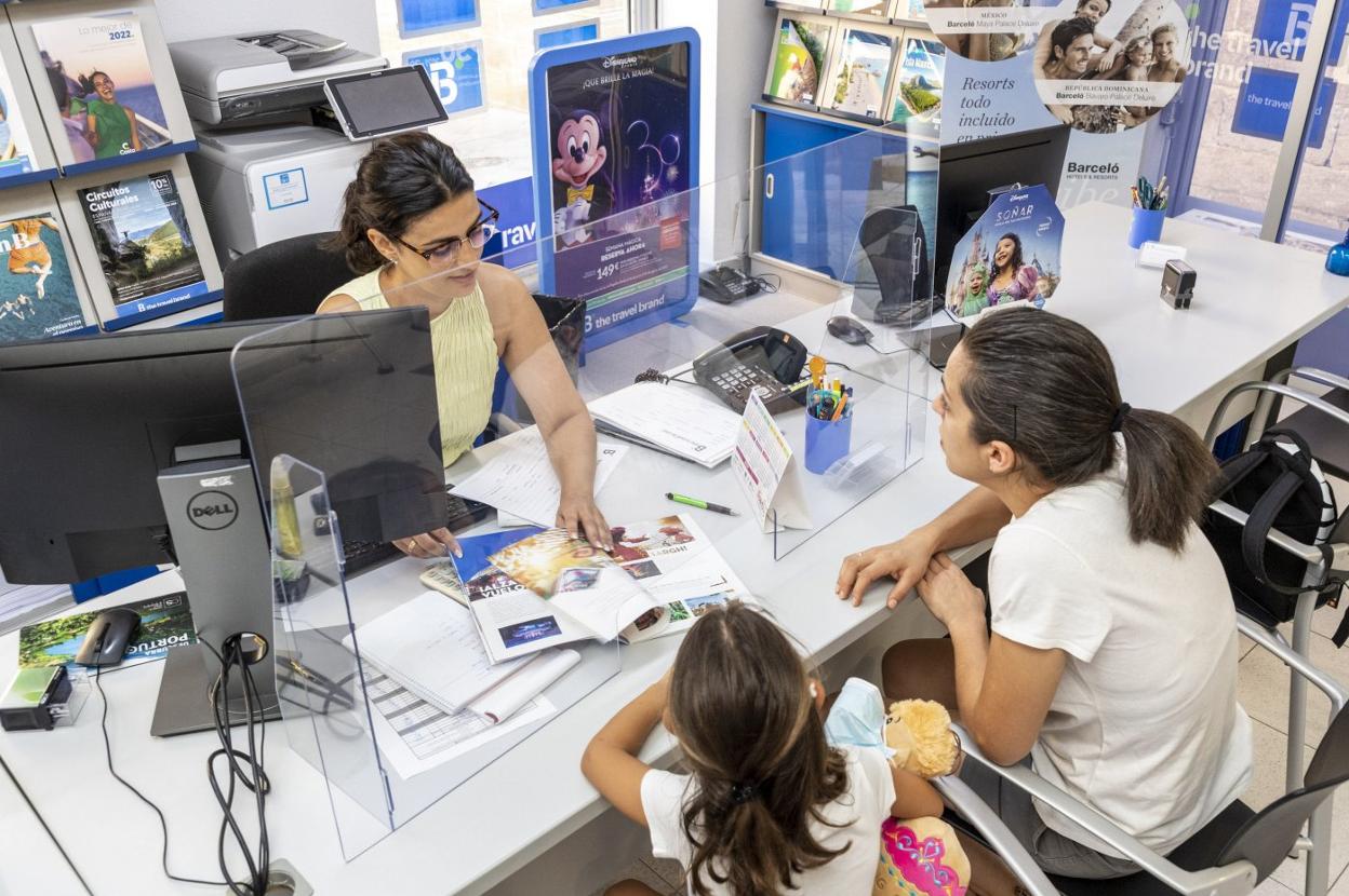 La empleada de una agencia informa sobre opciones de viajes a una clienta. 