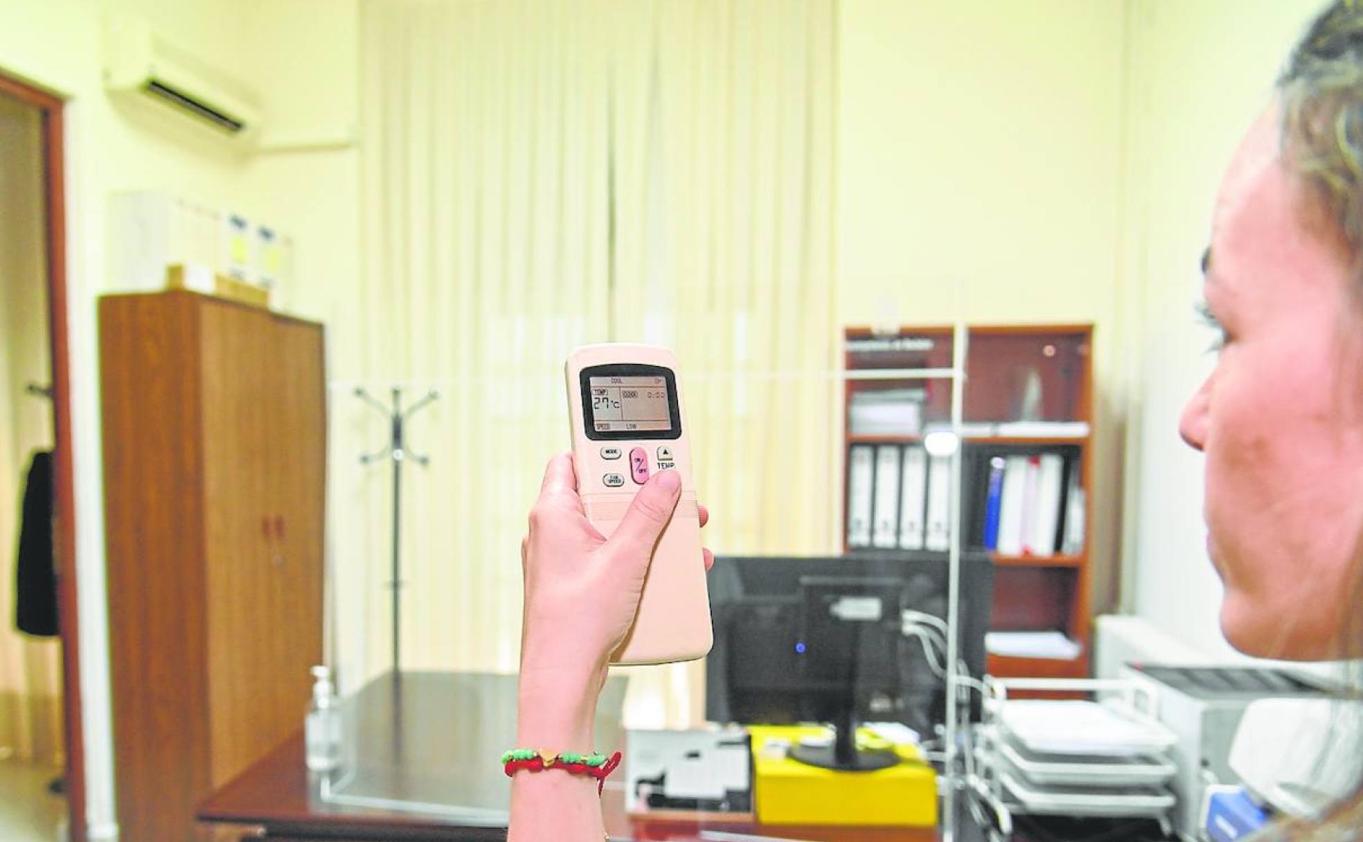 Una funcionaria fija la temperatura a 27 grados en una oficina del Ayuntamiento de Badajoz. 