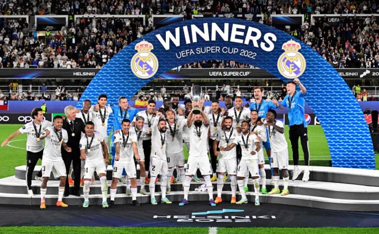 Karim Benzema levanta el trofeo de la Supercopa conquistado por el Real Madrid en Helsinki.