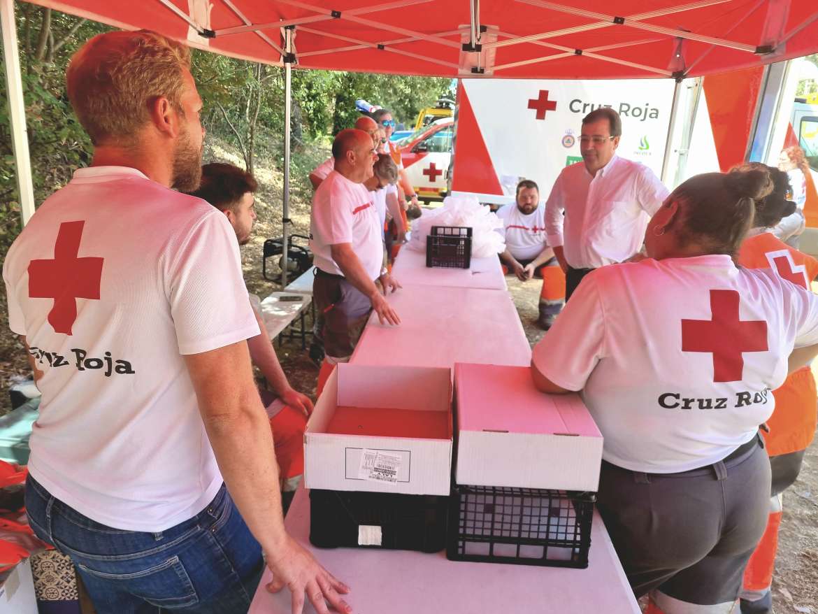 El presidente de la Junta habla con los voluntarios de Cruz Roja que atienden a los evacuados en Moraleja. 