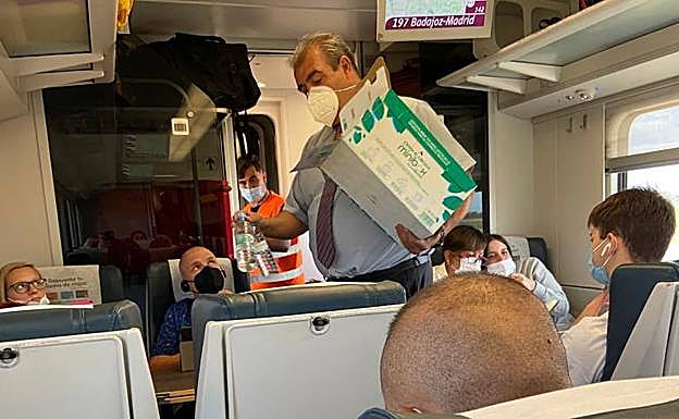 Un revisor reparte agua que han subido al tren en Talavera.