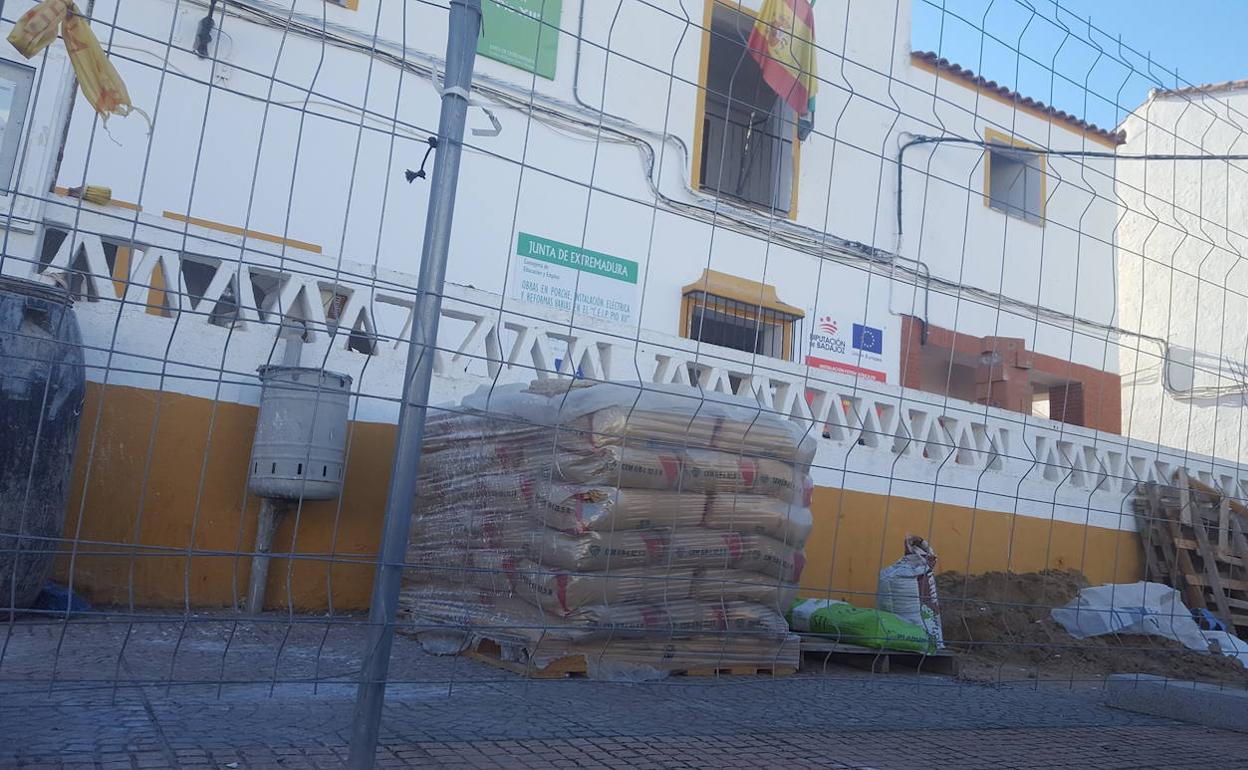 El colegio de La Morera está rodeado de vallas y materiales de construcción; abajo, el traslado de las sillas en coche particula