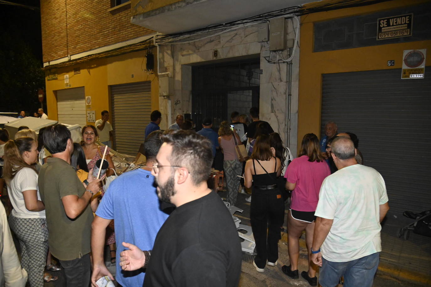 Vecinos protestando anoche en el rellano del piso okupado en Badajoz. 