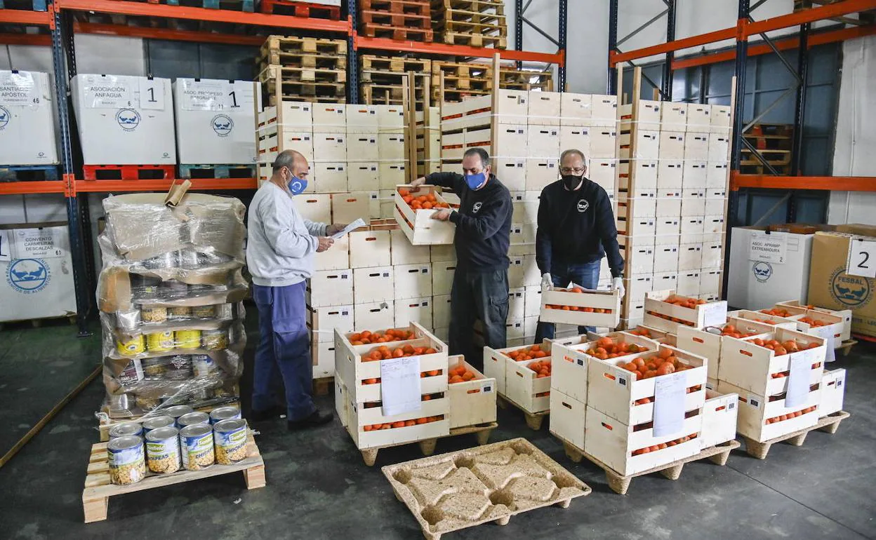 Voluntarios del Banco de Alimentos de Badajoz junto a los productos almacenados hace unos meses. 