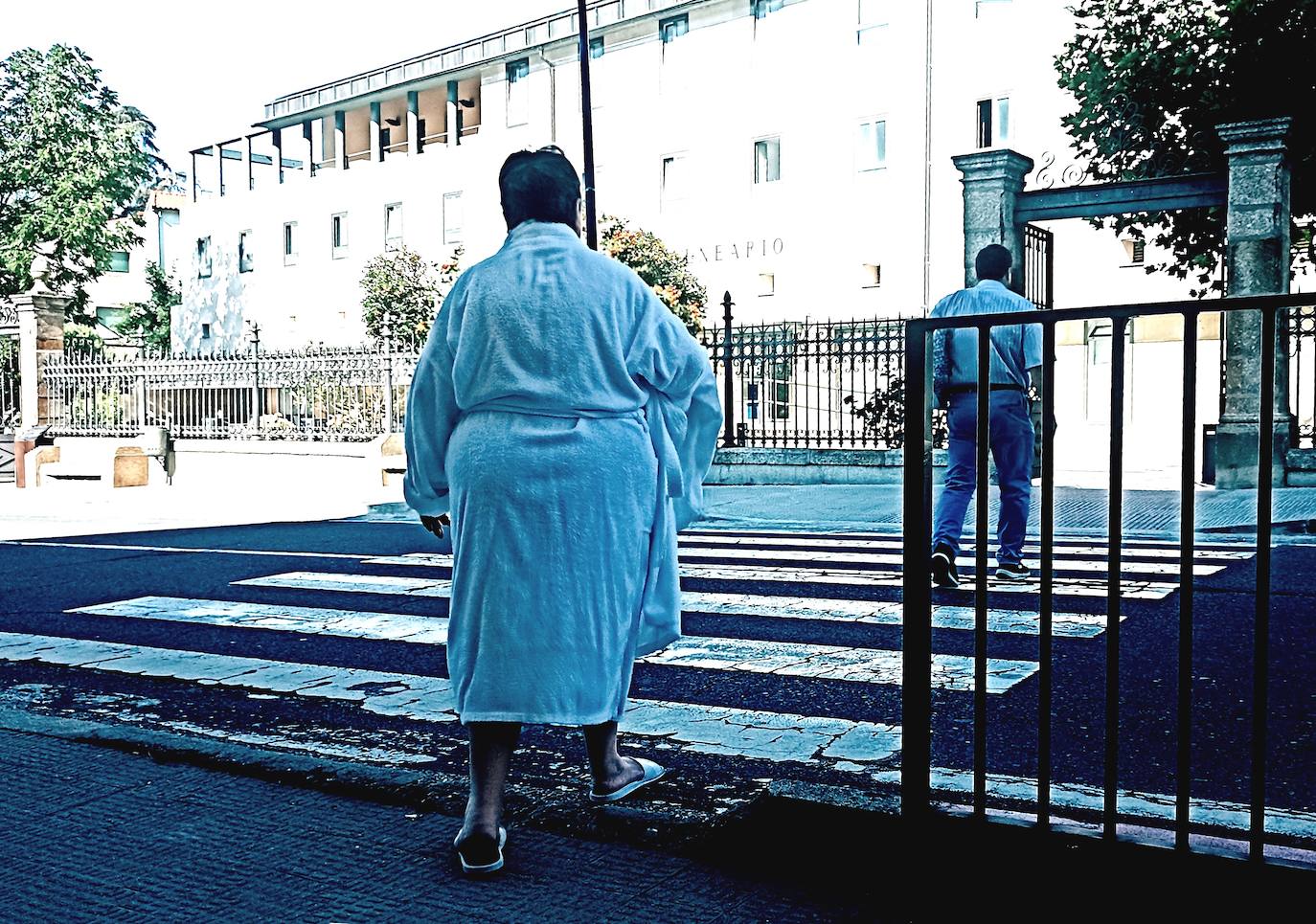 Mujer en albornoz cruzando la calle hacia el Balneario.