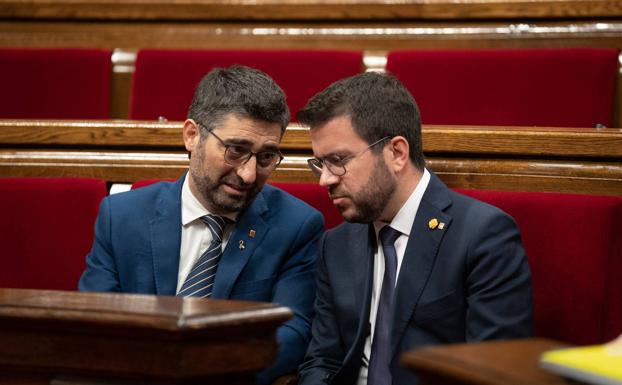 El exvicepresidente de la Generalitat, Jordi Puigneró (Junts), conversa en el Parlament con el presidente Pere Aragonès (ERC).