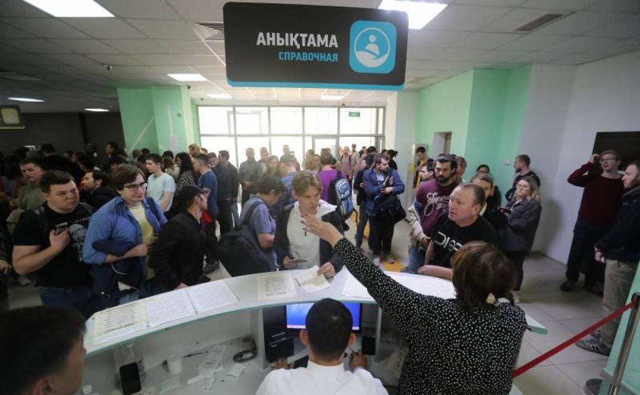 Ciudadanos rusos huidos a Kazajistán para escapar de la movilización parcial decretada por Putin hacen cola en un centro de Almaty para recibir un documento de residencia temporal. 