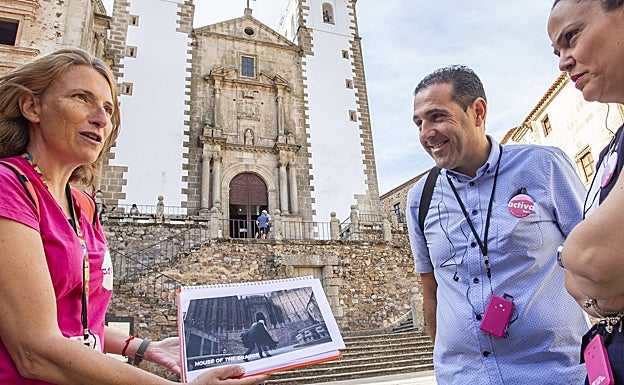 Carmen Alvarado muestra a los turistas una escena de 'La casa del dragón' rodada en la Plaza de San Jorge. 
