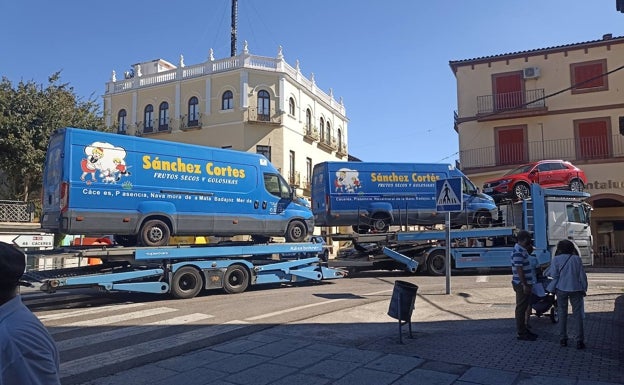 Un camión de transporte de vehículos pasando por Trujillo llevando dos furgonetas de Sánchez Cortés. 