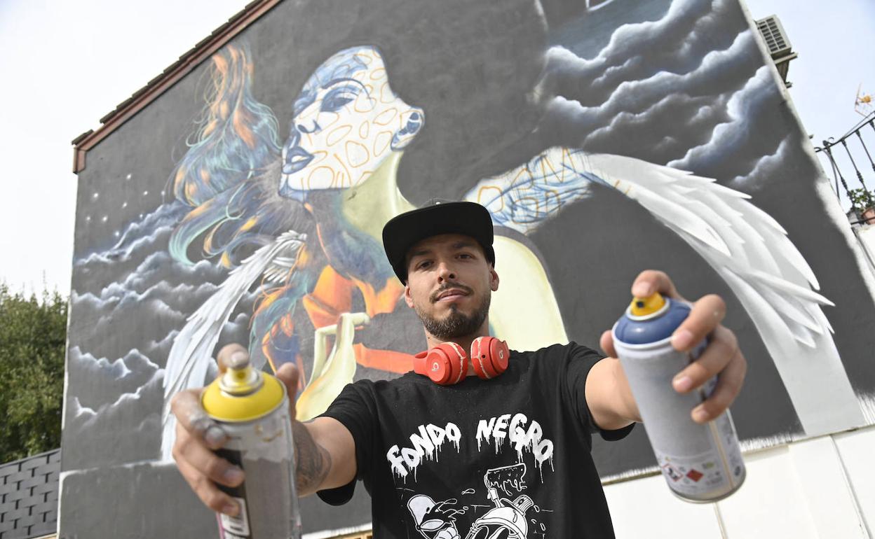 Alejandro Pajuelo 'Chino' posa con el mural sobre la riada. 