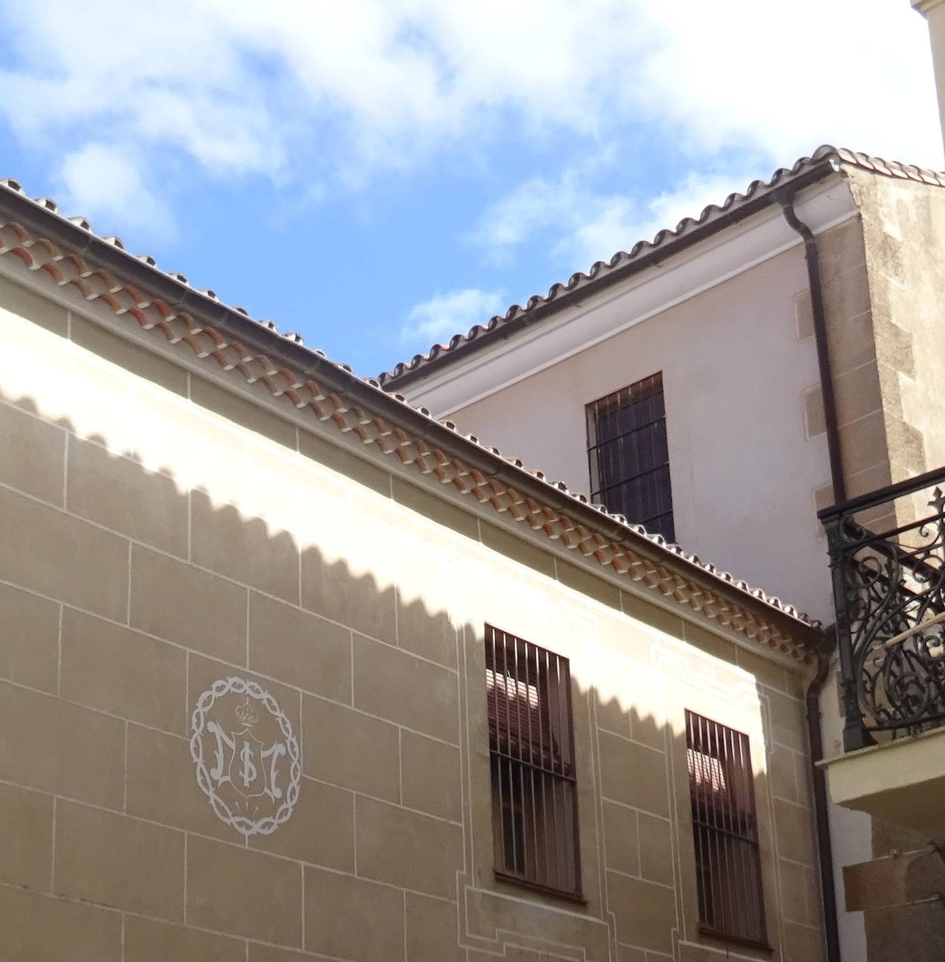 En el edificio por el Adarve del Cristo, permanece el esgrafiado del símbolo de las Siervas de María, que llegaron a Cáceres en 1901 y se fueron en 2005.