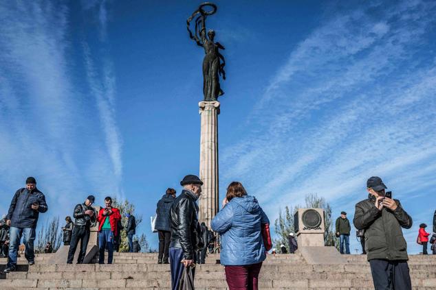 La gente se reúne en un lugar alto mientras trata de recibir una menor señal de roaming móvil rusa que llega desde el otro lado del río Dnipro en la recién liberada Jersón, el 14 de noviembre de 2022.