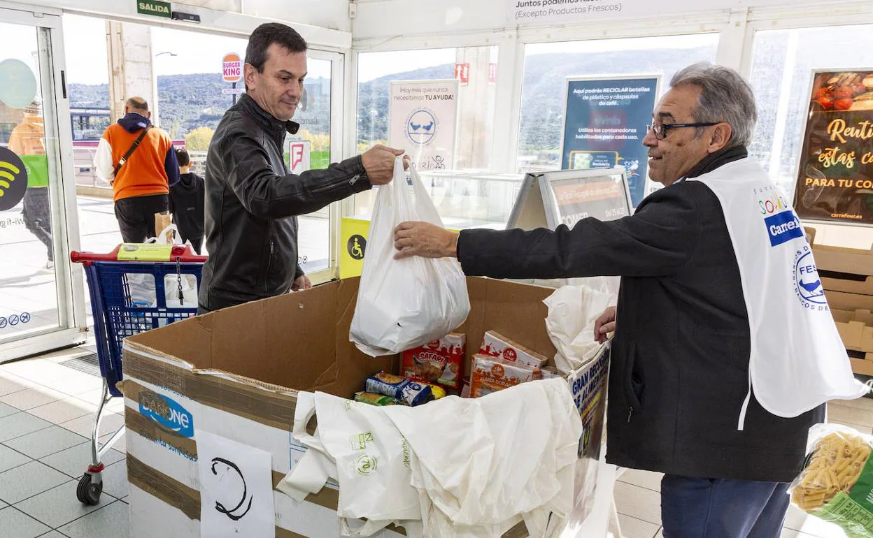 Un cliente dona una bolsa con alimentos en un supermercado de Plasencia. 