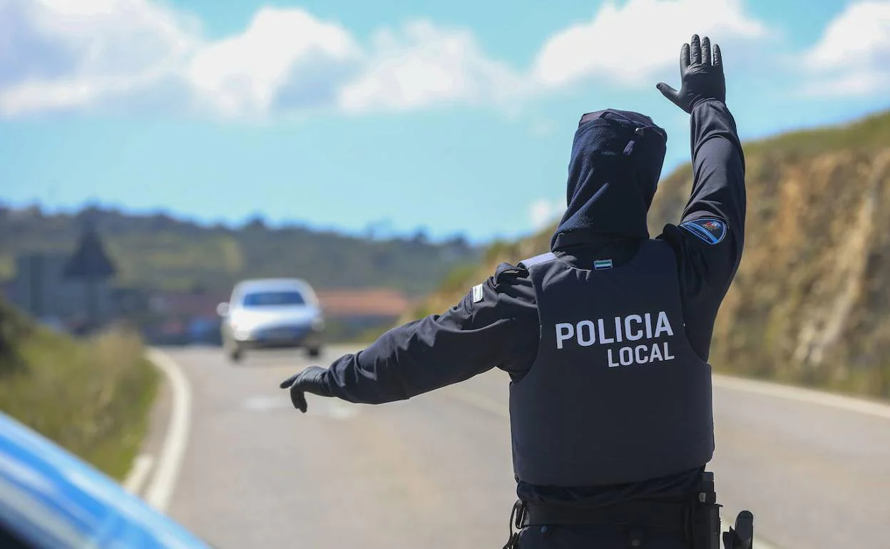 Un policía local de Cáceres dando al alto a un vehículo en un control. 