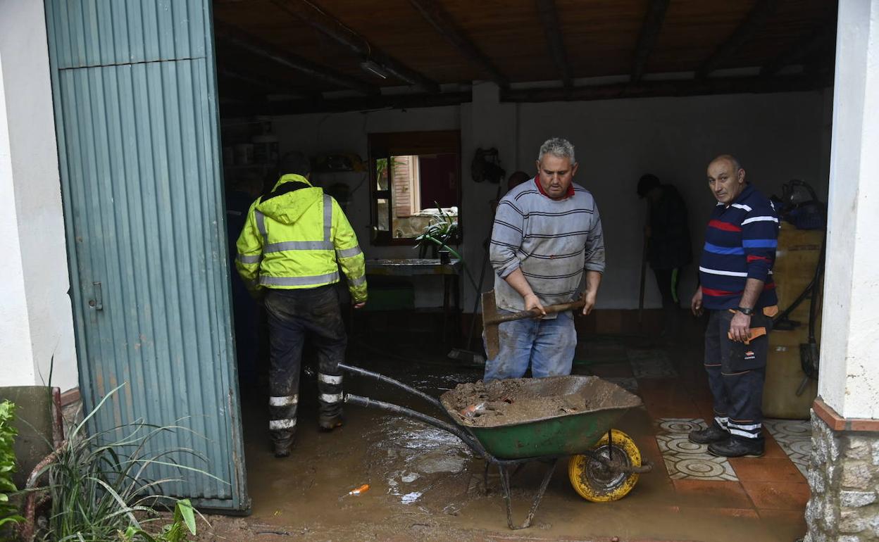 Tareas de limpieza de garajes inundados en La Roca de la Sierra, este martes.