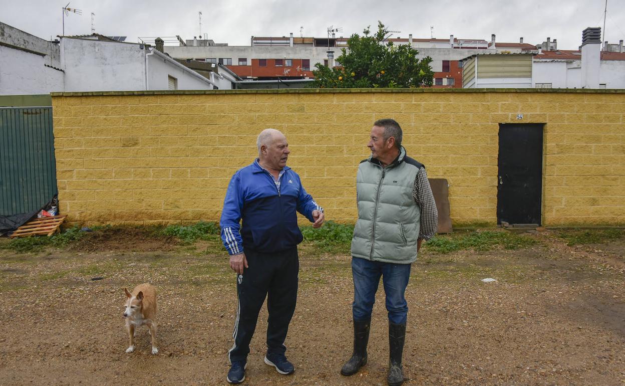 Rodrigo Aliseda (izquierda), tras sacar el agua y el barro de su patio, comenta con Isidro Gallego las incidencias de la noche. 