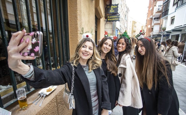 Imagen principal - Varios grupos disfrutando de las cañas de Nochebuena en el centro. la zona 'de los obispos' se puso a rebosar desde mediodía en Nochebuena. 