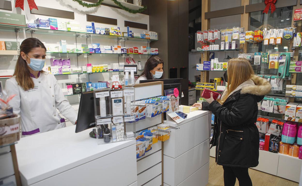 Una clienta de una farmacia cacereña comprando medicamentos. 