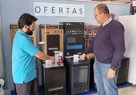 Una persona consulta en una tienda sobre estufas en venta.