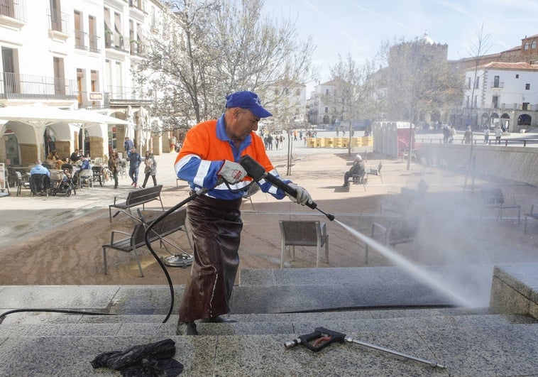 Un operario de Conyser limpia con un equipo a presión las escaleras situadas junto a la zona ajardinada de la Plaza Mayor.