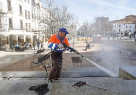 Un operario de Conyser limpia con un equipo a presión las escaleras situadas junto a la zona ajardinada de la Plaza Mayor.