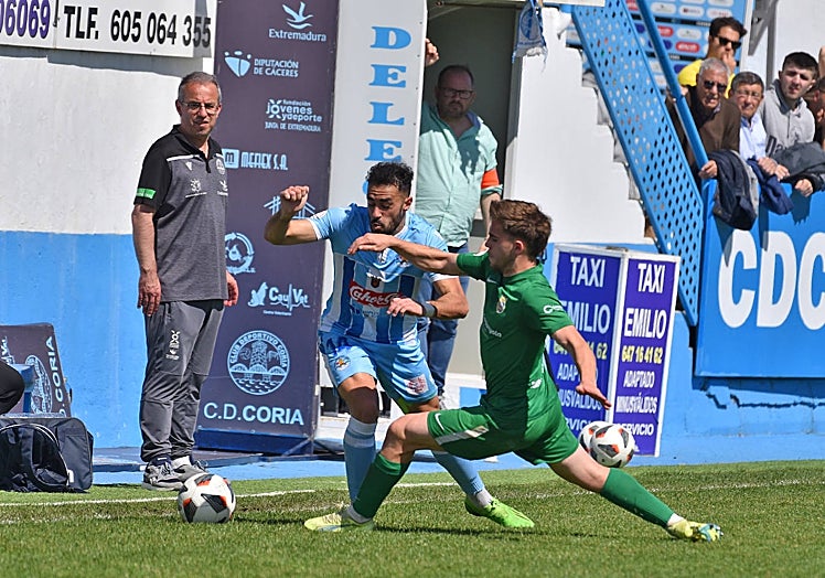 Alberto Urquía (izquierda) siguiendo desde la banda su último partido al frente del Coria.