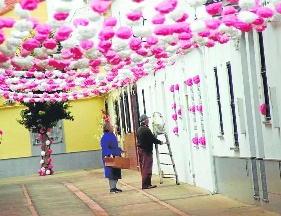 Los propios vecinos engalanan sus calles para la fiesta.