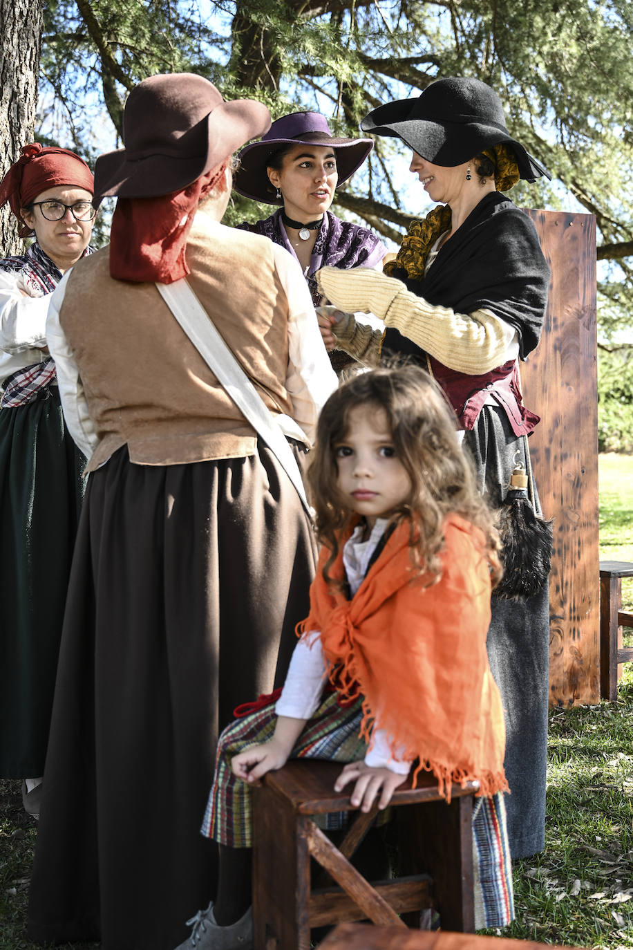 Un grupo de mujeres charla mientras una niña mira a la cámara.