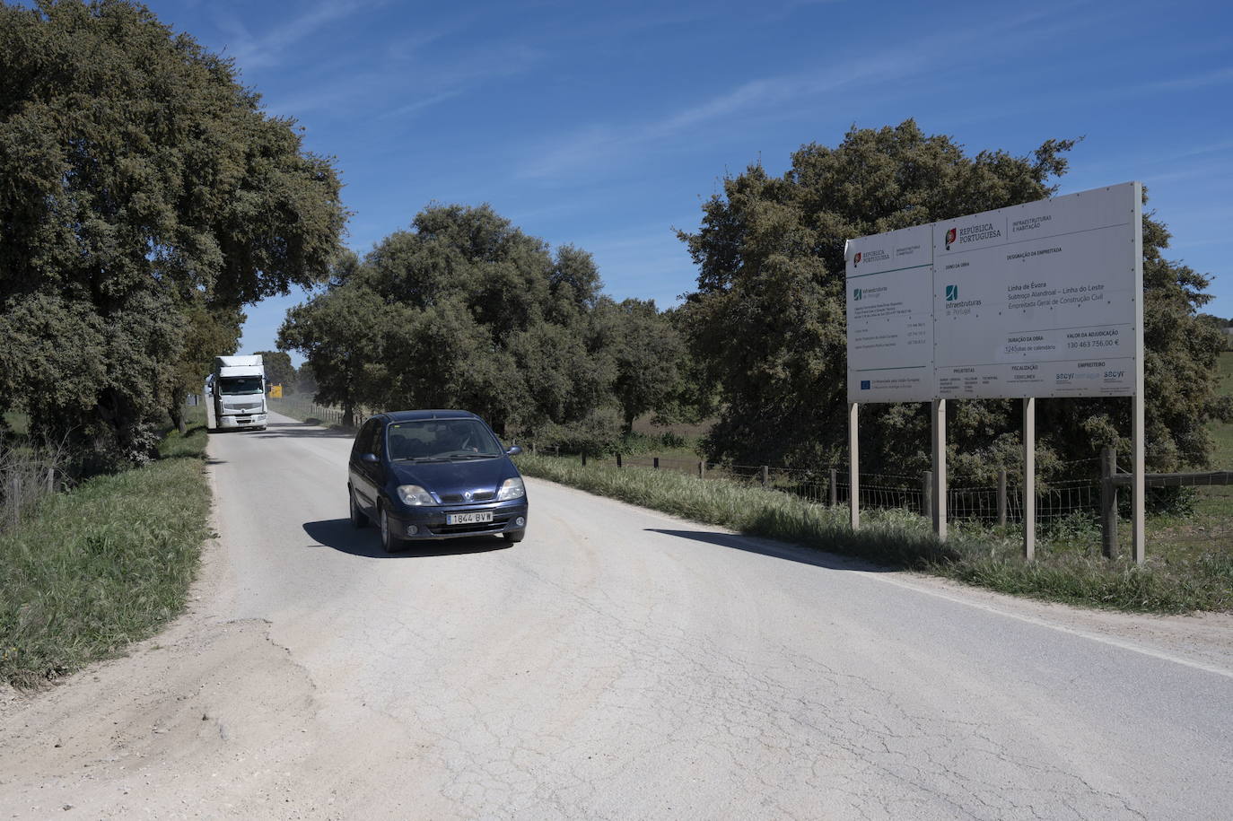 Un conductor circula junto al cartel que informa de las obras de la nueva línea.