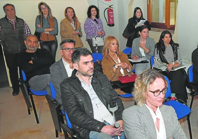 Arriba, asistentes al acto durante las intervenciones. Debajo, en el recorrido por la exposición de imágenes y portadas históricas del HOY.