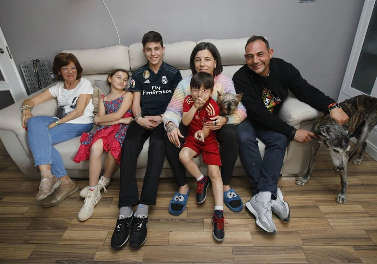 José Manuel y Marta con sus tres hijos, con Celia (la abuela) y sus dos perros en el salón de su casa en Cáceres.