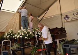 Preparando el manto y las flores blancas para salir hoy en procesión.