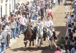 Tres jinetes cruzan La Corredera ante el numeroso público que no se ha querido perder el Día de la Luz.