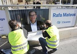 Dos operarios colocando carteles de Rafael Mateos en la avenida Clara Campoamor el pasado mes de marzo.