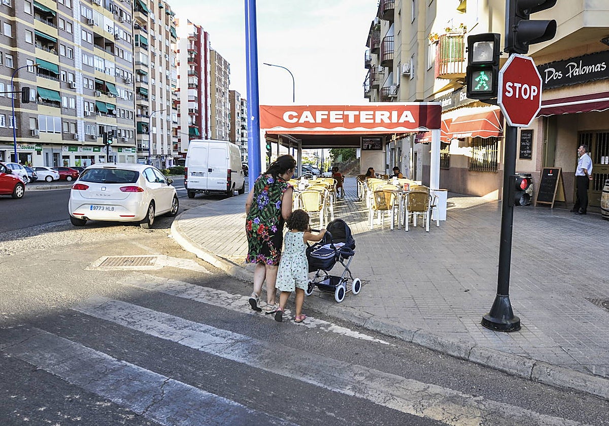 Una mujer cruza un paso de patones con un bebé y una niña en una imagen de archivo.