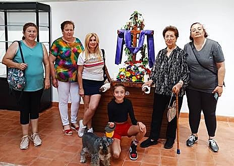 Imagen secundaria 1 - Arriba, mujeres de la asociación 'Amanecer', con su cruz hecha con flores de bolsas de plástico. Abajo, componentes de la asociación 'La Esperanza' con su cruz, y la niña Marina García Correa, con una cruz tradicional en silla.