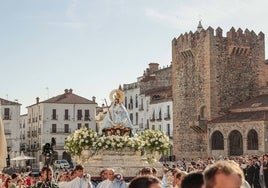 La Virgen de la Montaña, con la Torre de Bujaco de fondo, a su paso por la Plaza Mayor este domingo por la Mañana.