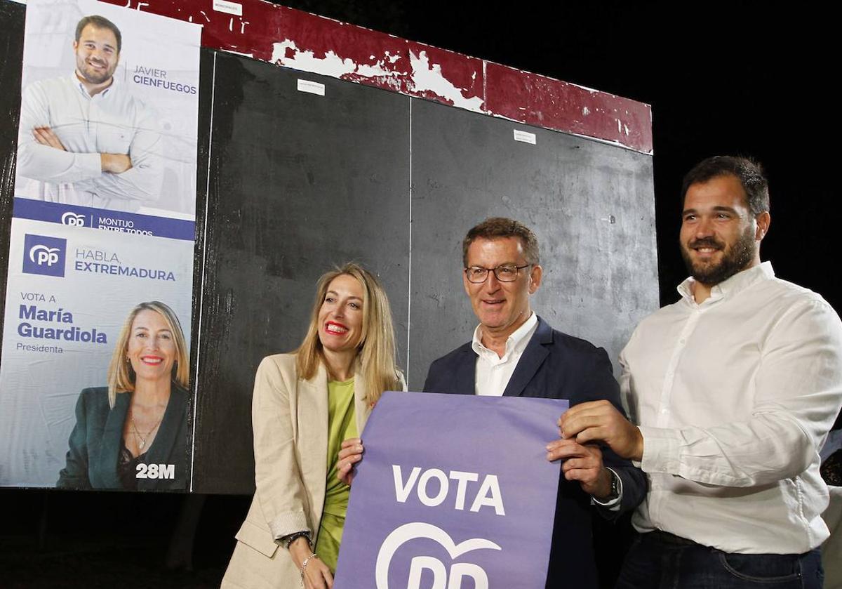 Guardiola, Feijóo y Cienfuegos durante la pegada de carteles, anoche en Montijo.