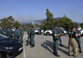 Agentes de la Guardia Civil, en Pinofranqueado, en la sede de la BRIF. Tras ellos, el incendio.