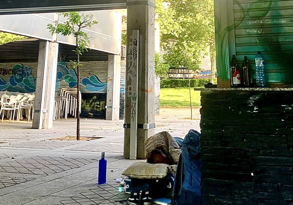 Una persona utiliza el quiosco del Perú para dormir y se ven botellas de cerveza y agua en la barra.