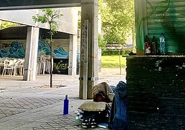 Una persona utiliza el quiosco del Perú para dormir y se ven botellas de cerveza y agua en la barra.