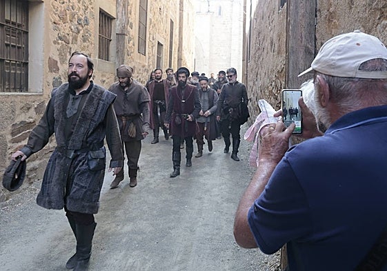 Un turista aprovecha la salida de los actores y figurantes de la plaza de Santa María para hacerles una fotografía.