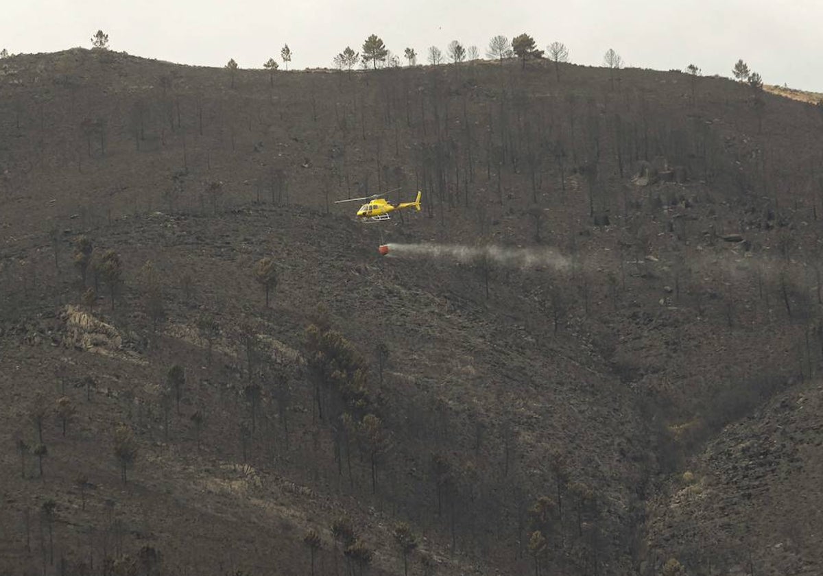 Un helicóptero sobrevuela el paisaje quemado en Las Hurdes.