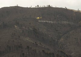 Un helicóptero sobrevuela el paisaje quemado en Las Hurdes.